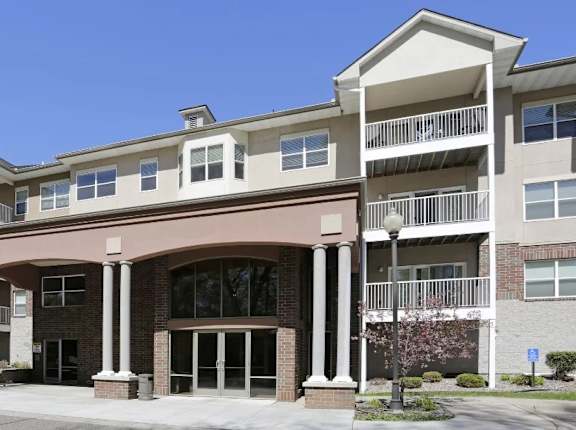 A large apartment building with a covered entrance and balconies.