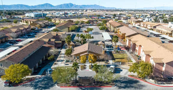 A large housing complex with a central courtyard and a mountain range in the distance.