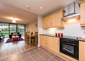 Thumbnail 5 of 7 - a kitchen and living room with a table and chairs