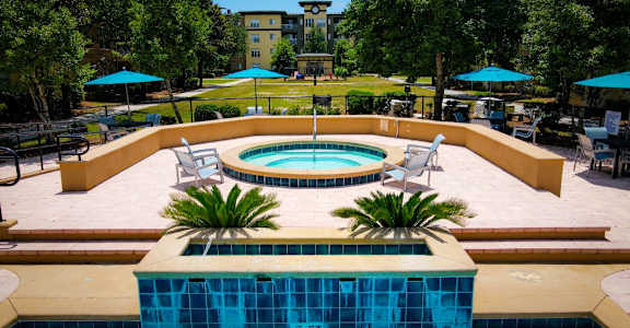 A pool surrounded by a patio and trees.at Elan Apartments, Fort Walton Beach, 32547