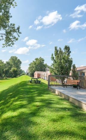 a patio with a grill and a swimming pool with umbrellas at Brightwaters Apartments, Little Rock, Arkansas