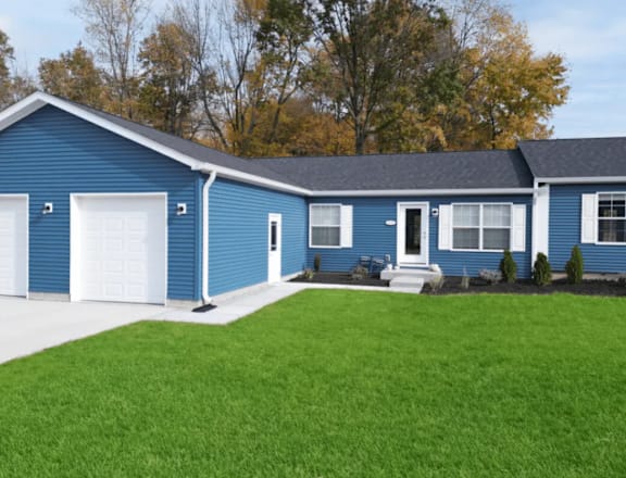 A blue house with a white garage door and a white front door.
