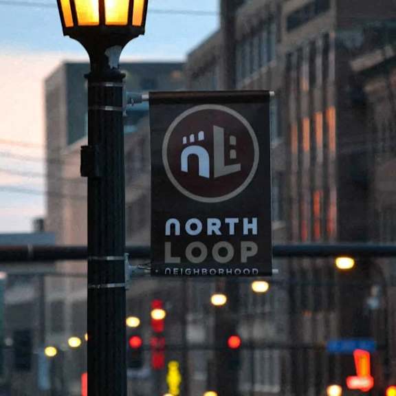 A sign for the North Loop neighborhood is displayed on a pole.