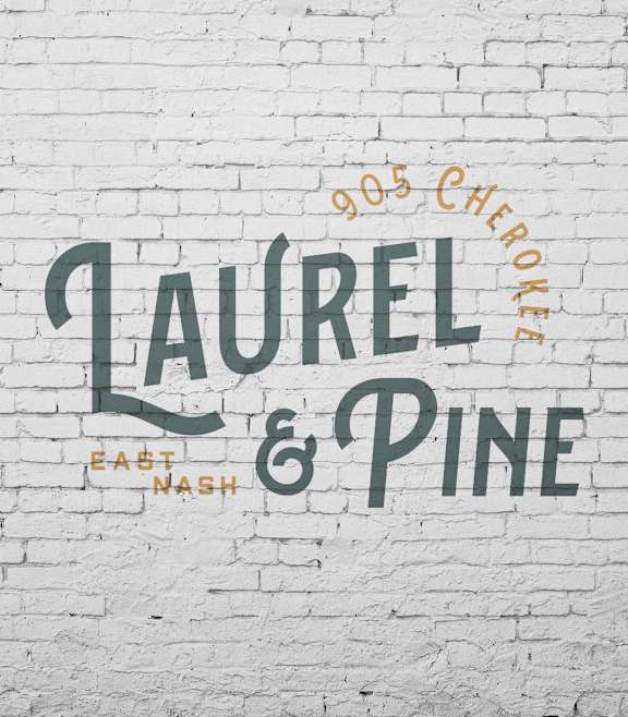 A white brick wall with a sign that says Laurel and Pine.