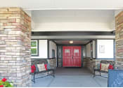 Thumbnail 2 of 18 - a red door on a building with a porch with two benches and a chalkboard sign