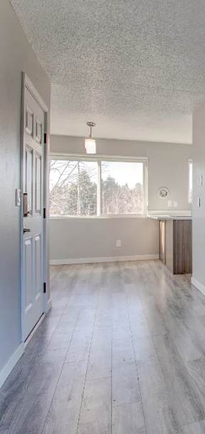 A spacious room with wood flooring and white walls at Tigardville Apartments, Tigard 97223