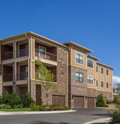 Apartment building with brown and beige exterior and multiple balconies.