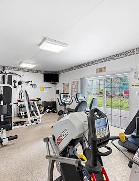 A gym with a rowing machine and other exercise equipment.