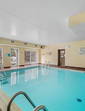 A large indoor swimming pool with a glass divider.