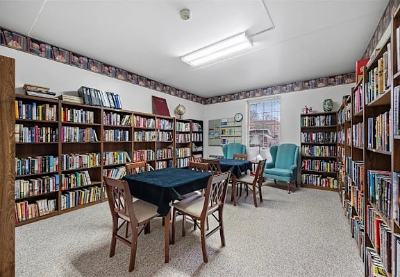 A room filled with bookshelves and a table with chairs.
