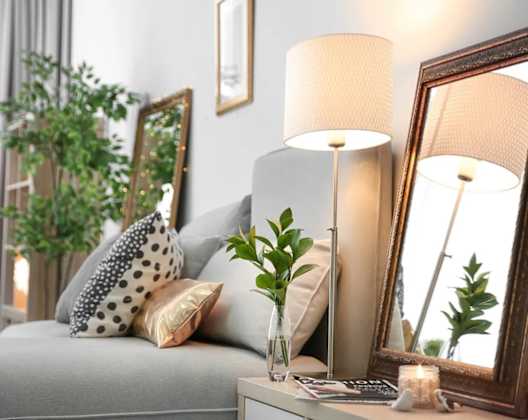 a living room with a couch and a table with a vase with a plant on it