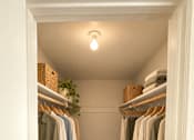 Thumbnail 5 of 11 - A hallway with clothes hanging on a rack and a basket on the floor at Lifestyle at Shreveport in Shreveport, LA, 71109.