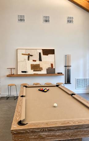 A pool table with a white ball in the middle of it.