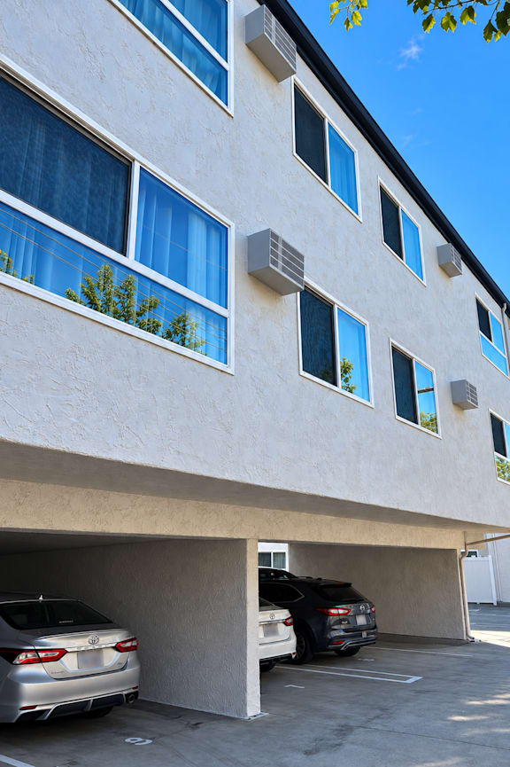 A white building with a car parked in front of it.