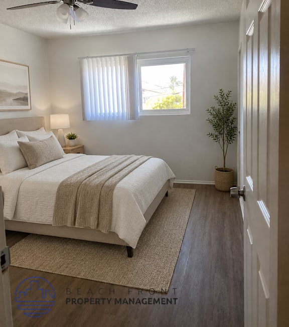 A well-lit bedroom with a large bed and a painting on the wall.