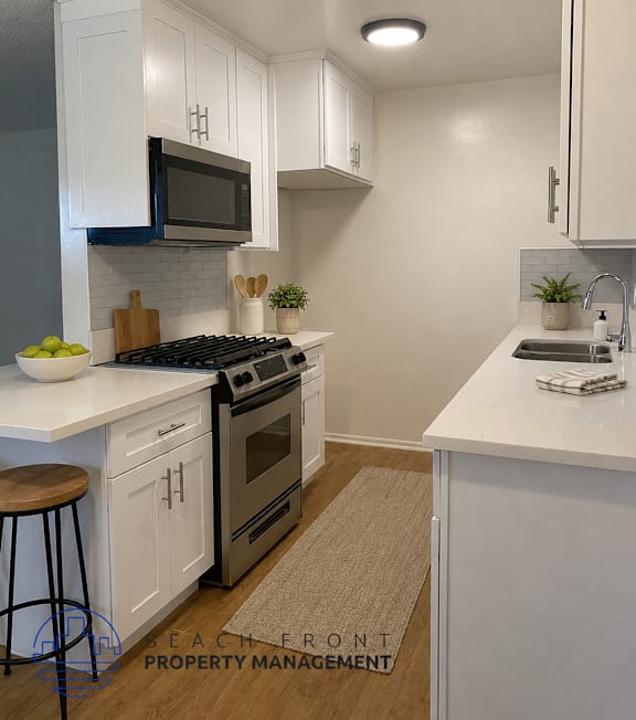 A well-lit, modern kitchen and living room with a dining area.