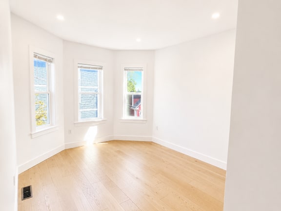 A room with wooden flooring and white walls.