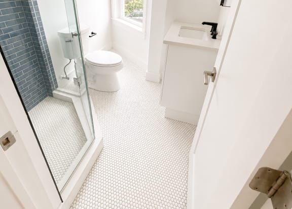 A white bathroom with a walk in shower.