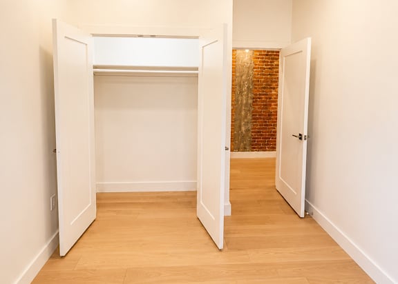A hallway with a brick wall and white walls.