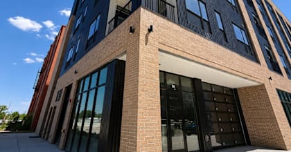 A modern building with a glass facade and a brick base.