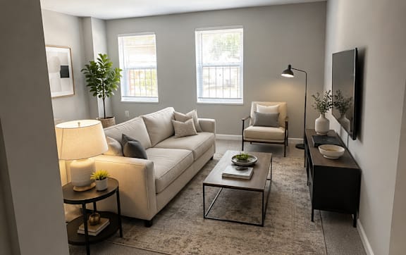A living room with a white couch, a grey rug, and a black coffee table.