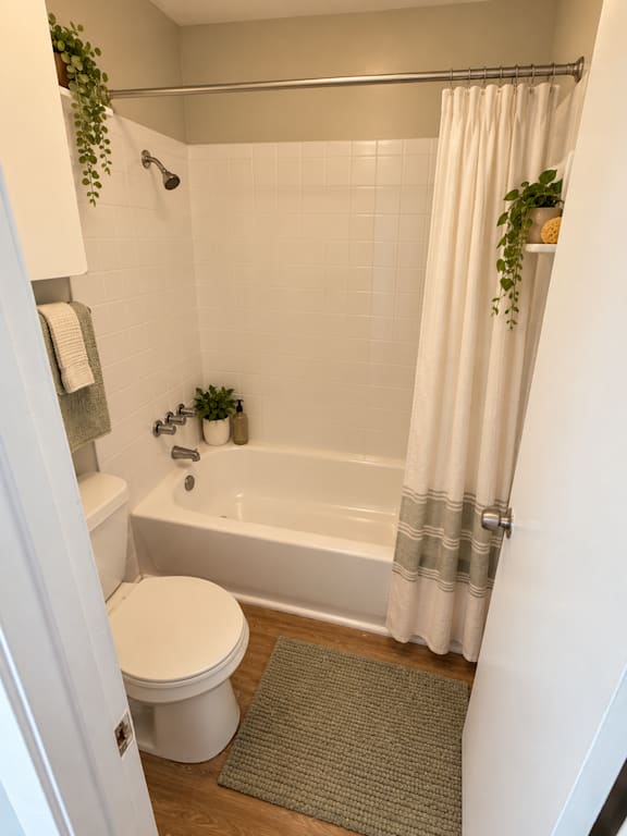 A white toilet sits next to a bathtub in a bathroom at Lifestyle at Shreveport in Shreveport, LA, 71109.