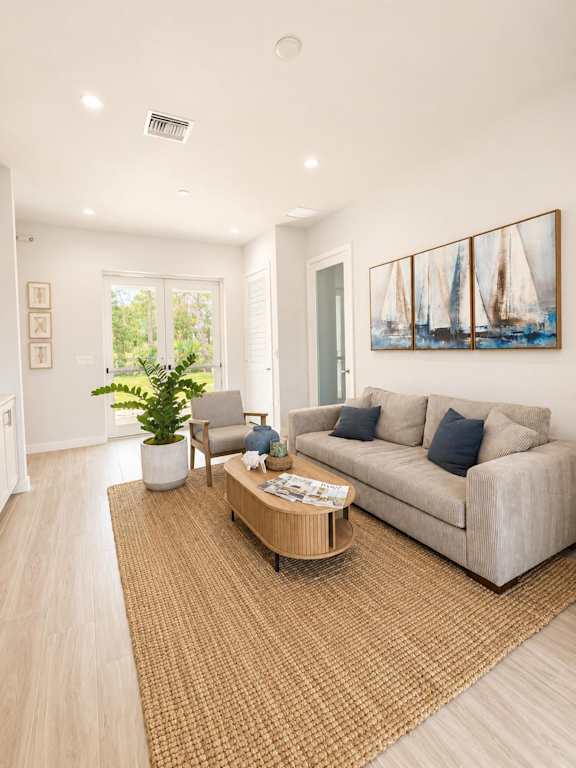 A living room with a couch, a chair, a coffee table, and a painting on the wall.