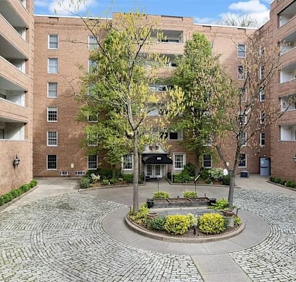 A courtyard with a fountain surrounded by brick buildings.