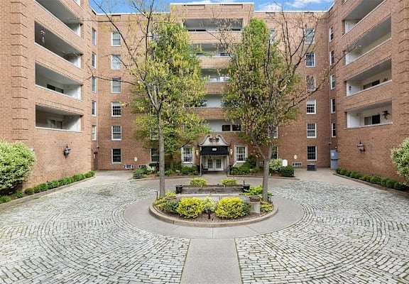 A courtyard with a circular brick design surrounded by apartment buildings.