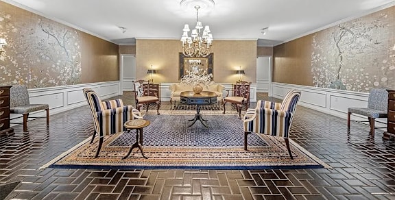 A dining room with a large table surrounded by chairs.