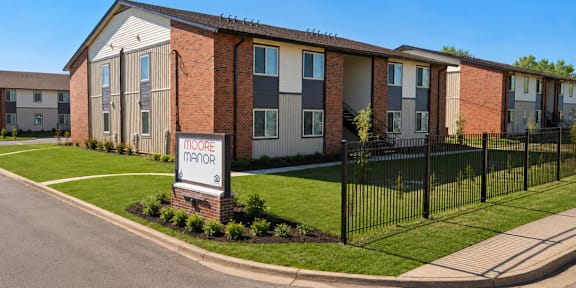 A row of townhouses with a sign that says Moore Manor.