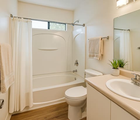 A white bathroom with a toilet, sink, and bathtub.