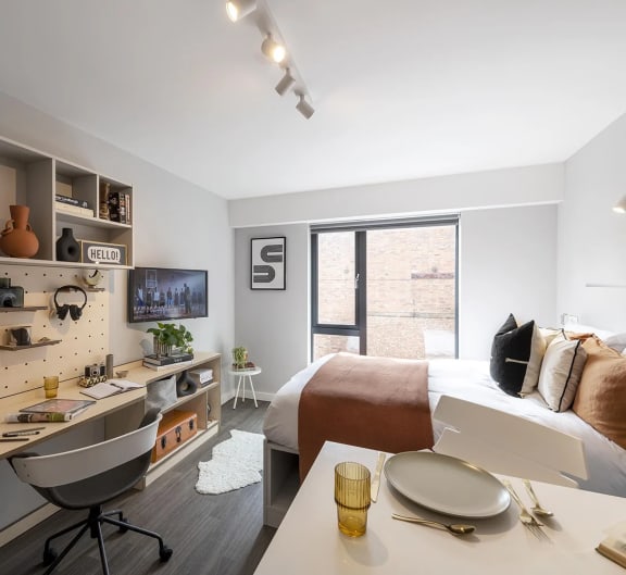 a bedroom with a bed and a desk and a window
