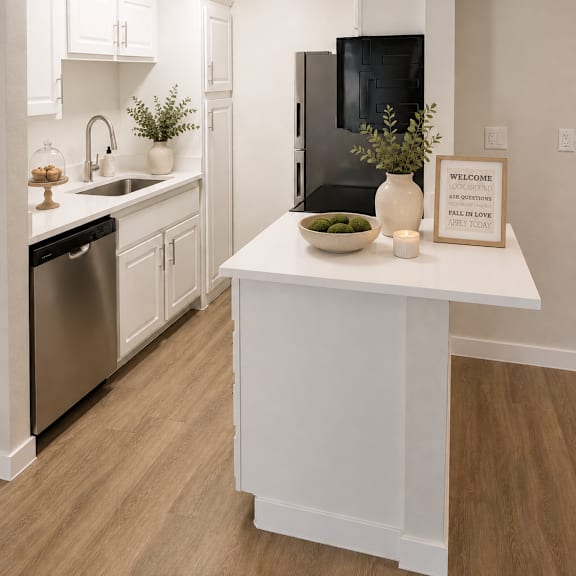 A kitchen with a black fridge and white cabinets.