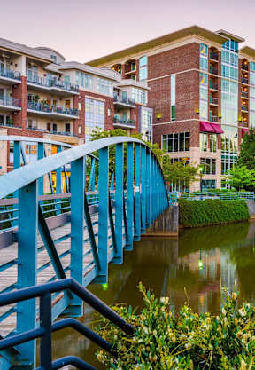 a blue bridge over a river in a city