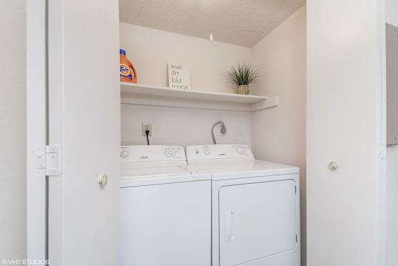 A small laundry room with a washer and dryer.