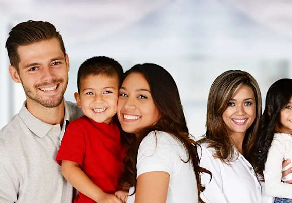 A family of six is standing together smiling.