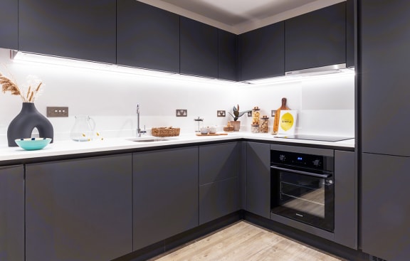 a kitchen with navy blue cabinets and a white counter top