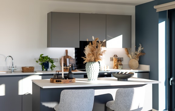 a kitchen with navy blue cabinets and a white counter top