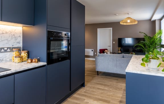 a kitchen with navy blue cabinets and a white counter top