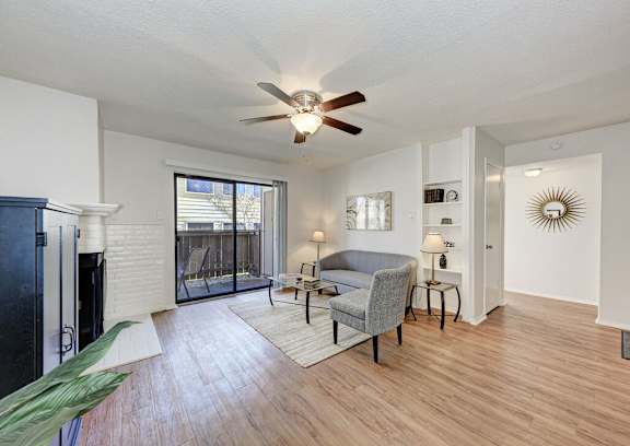 A living room with a grey couch and a ceiling fan.