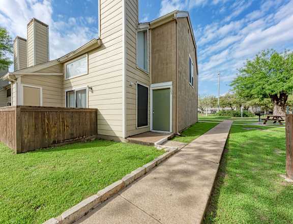 A modern house with a well-maintained lawn in front.