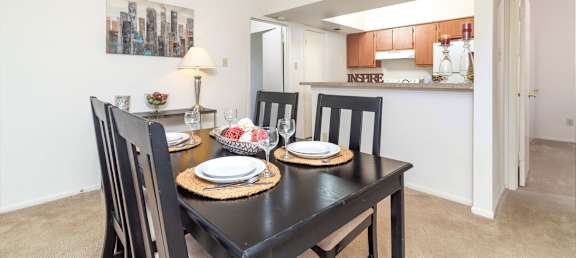 A dining room with a table set for two.