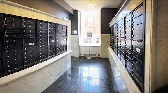 A long hallway with a row of mailboxes on either side.