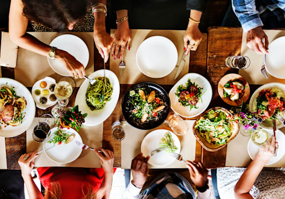 a group of people sitting at a table eating food