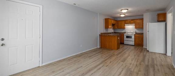 a kitchen and living room with a wooden floor