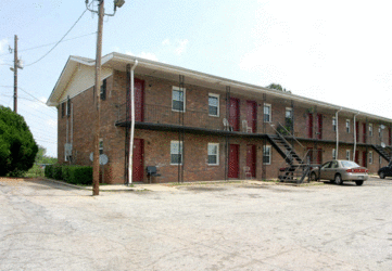 a large brick apartment building with a parking lot in front of it
