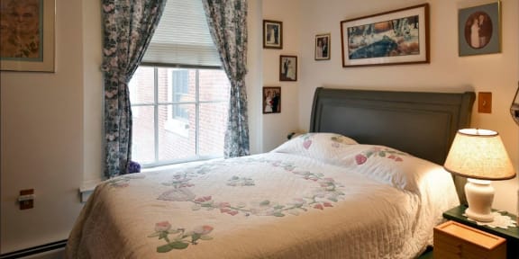a bedroom with a bed and curtains and a window