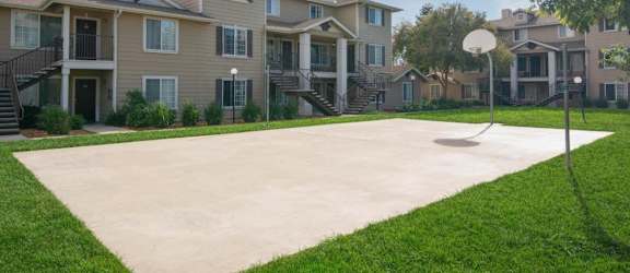 A basketball court in front of a row of houses.