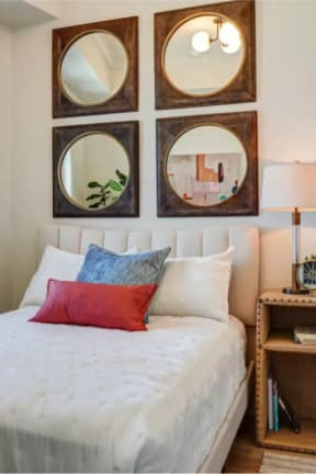 a bedroom with a white bed and mirrors on the wall